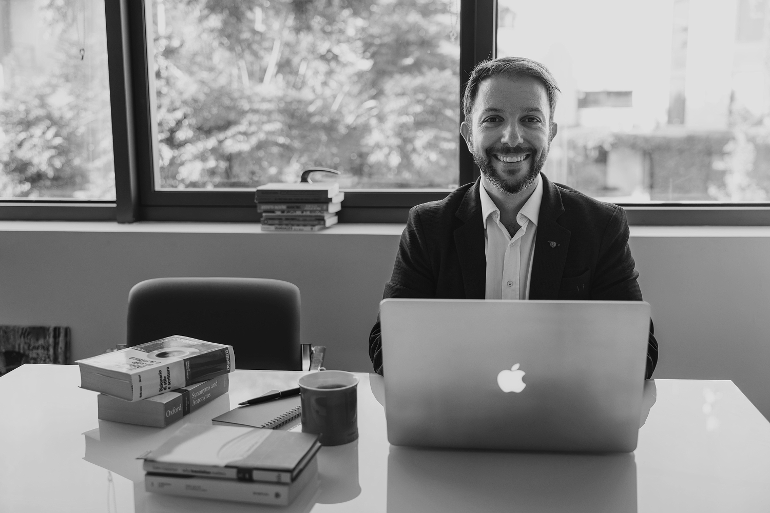 Matteo in front of a computer, looking to the camera with a smile in his face